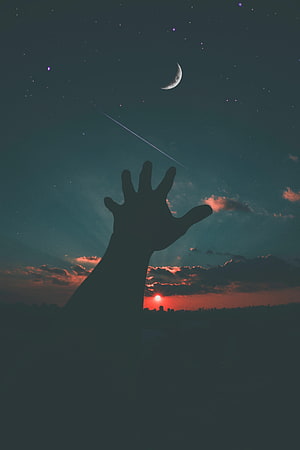 Silhouette of a Hand Reaching for the Moon and Stars at Sunset HD phone wallpaper