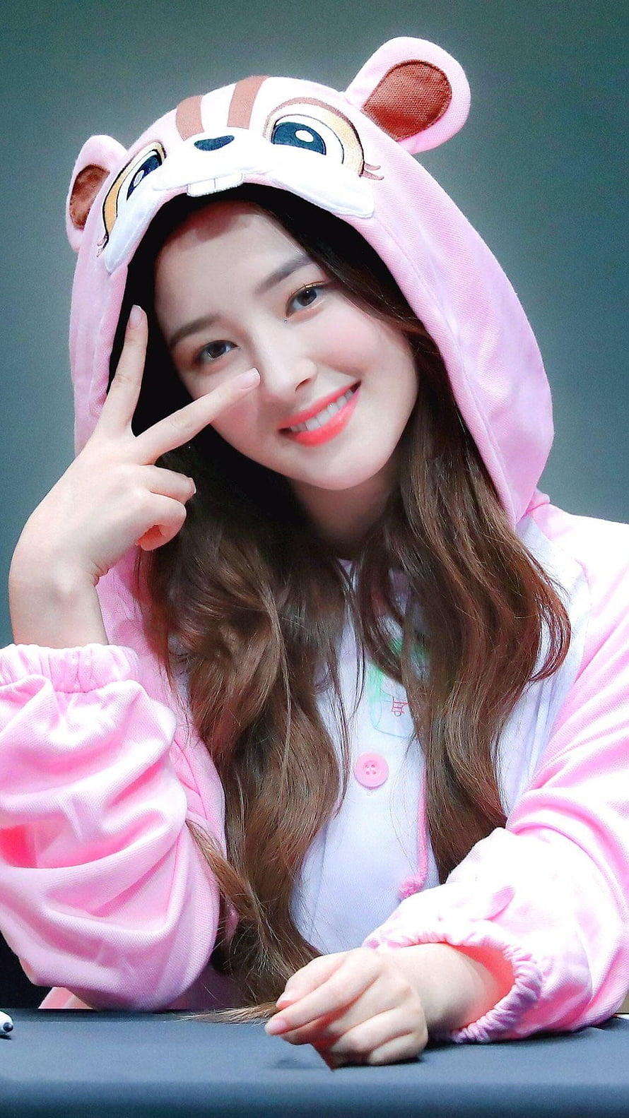 Nancy from Momoland in a cute pink animal onesie smiling and posing with a peace sign HD phone wallpaper