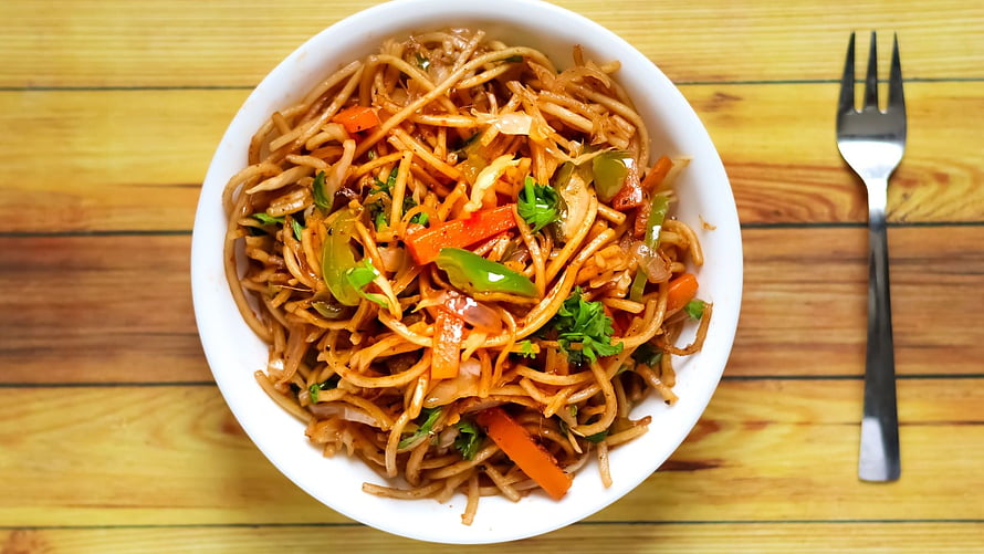 Street Style Veg Chowmein with Carrots and Peppers in a White Bowl on Wooden Table HD wallpaper