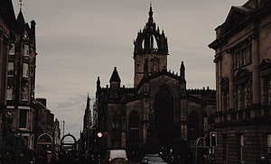 Gothic Cathedral Tower Rising Over Historic European Street at Dusk HD wallpaper