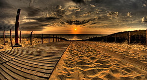 Dramatic Golden Hour Beach Sunset with Wooden Boardwalk and Sand Dunes HD wallpaper