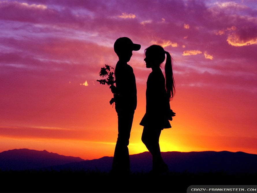 Silhouetted couple holding flowers against a vibrant sunset sky with distant mountains HD wallpaper