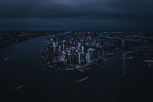 Aerial View of Manhattan Skyline at Night with Dark Cloudy Sky and City Lights, New york, city, aerial view, night, buildings HD wallpaper