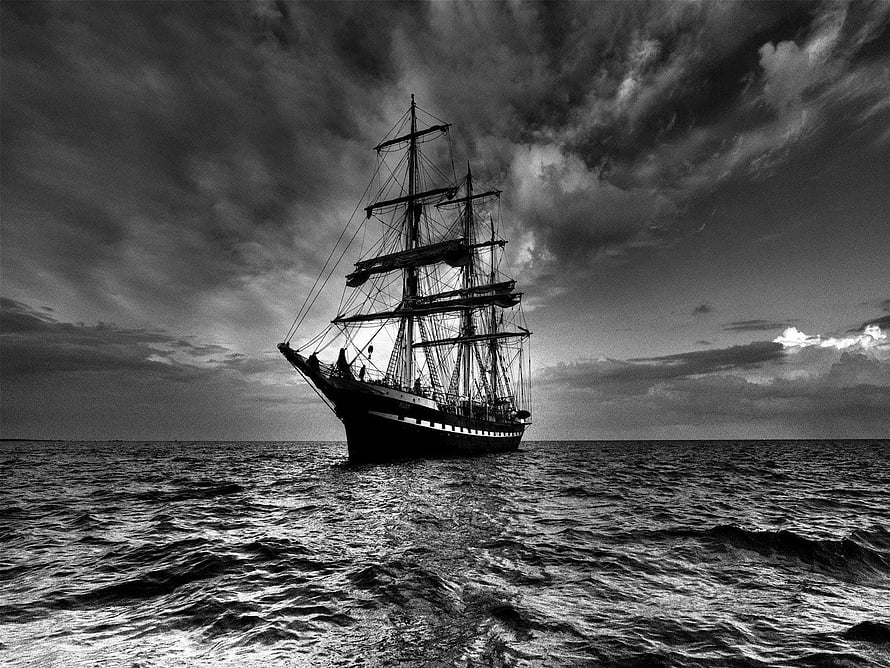 Monochromatic Tall Ship Sailing on Open Ocean Under Dramatic Stormy Skies HD wallpaper