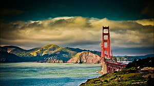 Golden Gate Bridge Tower Over San Francisco Bay With Dramatic Clouds and Green Hills HD wallpaper
