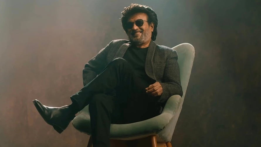 Rajinikanth in Jailer wearing sunglasses and a grey blazer seated in a modern chair HD wallpaper