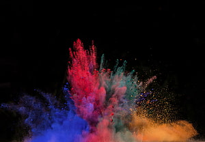 Vibrant multicolored powder explosion captured against a dark background HD wallpaper