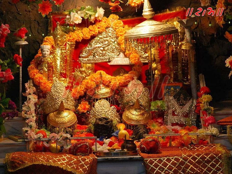 Traditional Hindu Shrine Decorated with Golden Statues and Marigold Garlands HD wallpaper
