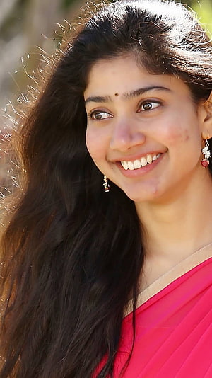Sai Pallavi smiling portrait in pink saree with long dark hair and traditional jewelry HD phone wallpaper