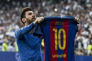 Lionel Messi holding up FC Barcelona jersey with number 10 and UNICEF logo HD wallpaper