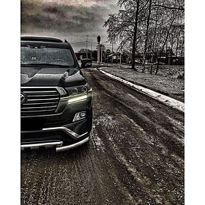 Black Toyota Land Cruiser on a Snowy Road with Dramatic Cloudy Sky HD phone wallpaper