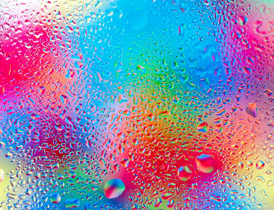 Vibrant Rainbow Water Droplets on Glass Surface with Prismatic Color Refraction HD wallpaper