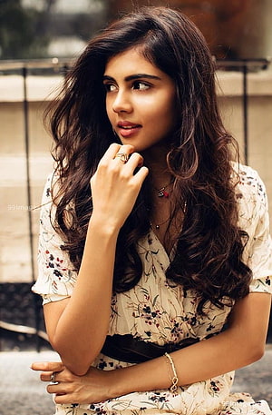 Kalyani Priyadarshan in a floral dress with long wavy hair and elegant jewelry HD phone wallpaper