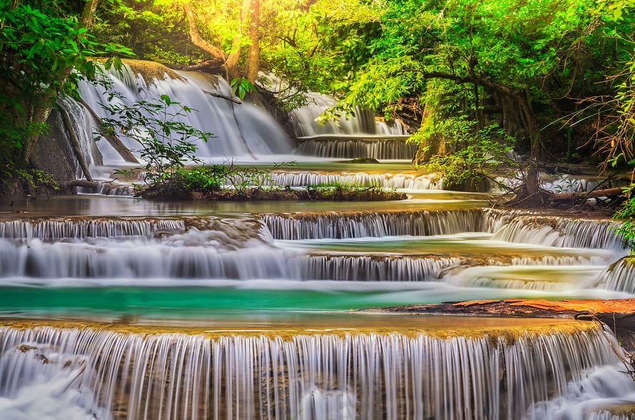 Serene Tiered Waterfall in Lush Green Forest with Smooth Flowing Water HD wallpaper
