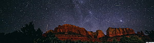 Meteor Shower Over Red Rock Canyon Under a Starry Night Sky HD wallpaper
