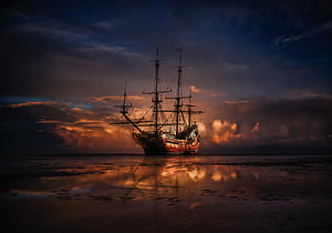 Silhouetted Tall Ship on Calm Waters at Golden Sunset HD wallpaper