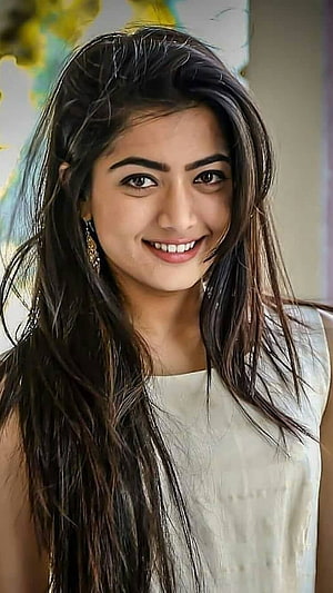 Rashmika Mandanna smiling portrait with long dark hair and white sleeveless top HD phone wallpaper
