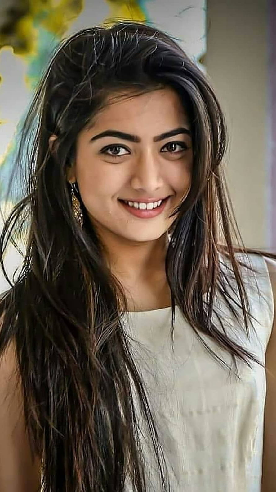 Rashmika Mandanna smiling portrait with long dark hair and white sleeveless top HD phone wallpaper
