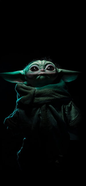 Grogu from The Mandalorian in a dark moody portrait with glowing green skin and large expressive eyes HD phone wallpaper