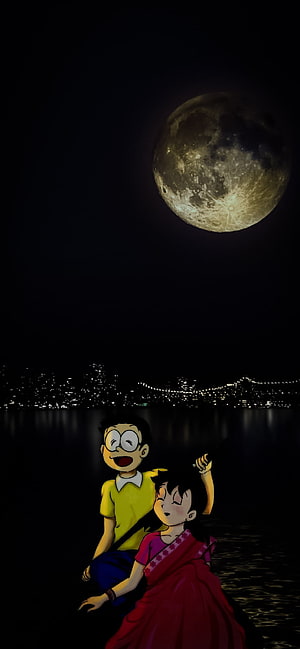 Nobita and Shizuka sitting by the water admiring a giant full moon over a city skyline HD phone wallpaper