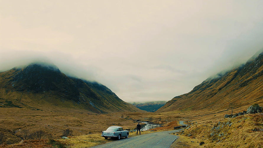 Vintage Silver Car Parked on a Winding Road in a Misty Mountain Valley HD wallpaper
