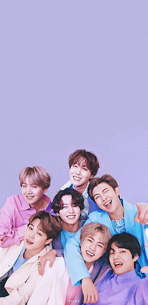 BTS members smiling and posing together in colorful pastel outfits against a light purple background HD phone wallpaper