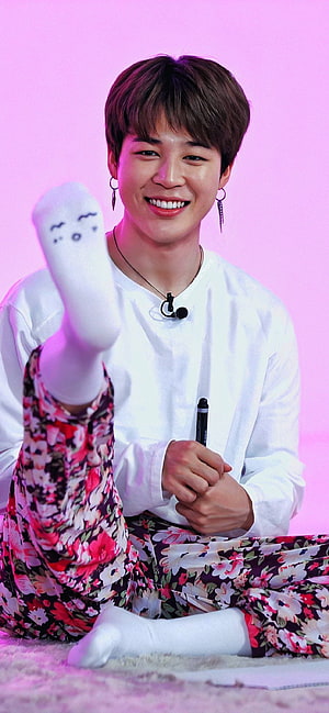 Park Jimin from BTS smiling in floral pants with a sock face on a pink background HD phone wallpaper