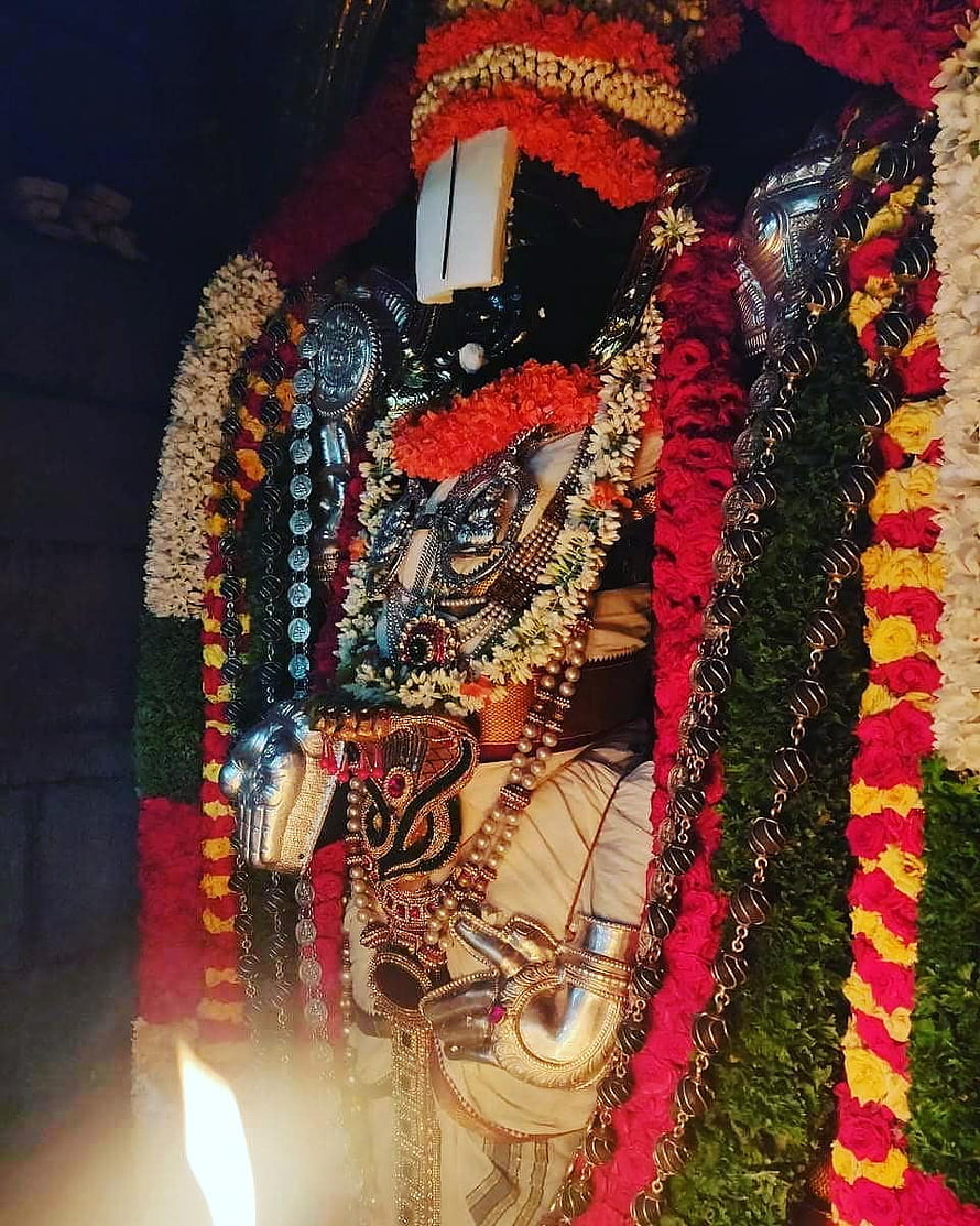 Decorated Hindu deity statue adorned with vibrant flower garlands and silver jewelry HD phone wallpaper