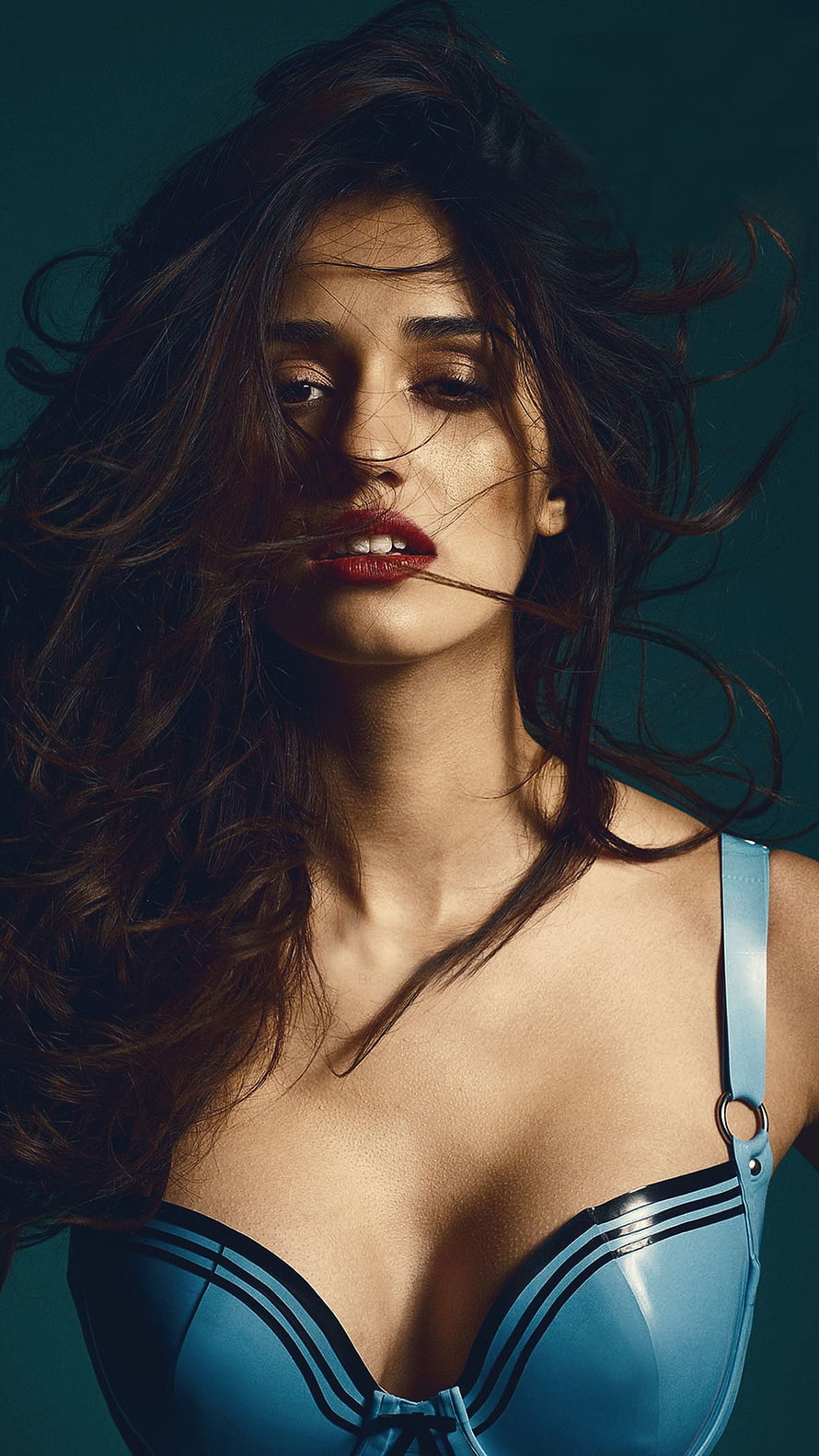 Disha Patani in a stylish blue latex outfit with dramatic lighting and windswept hair HD phone wallpaper