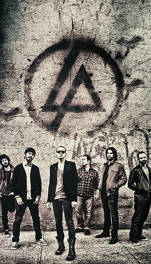 Linkin Park band members standing in front of a distressed wall with a large spray-painted logo HD phone wallpaper