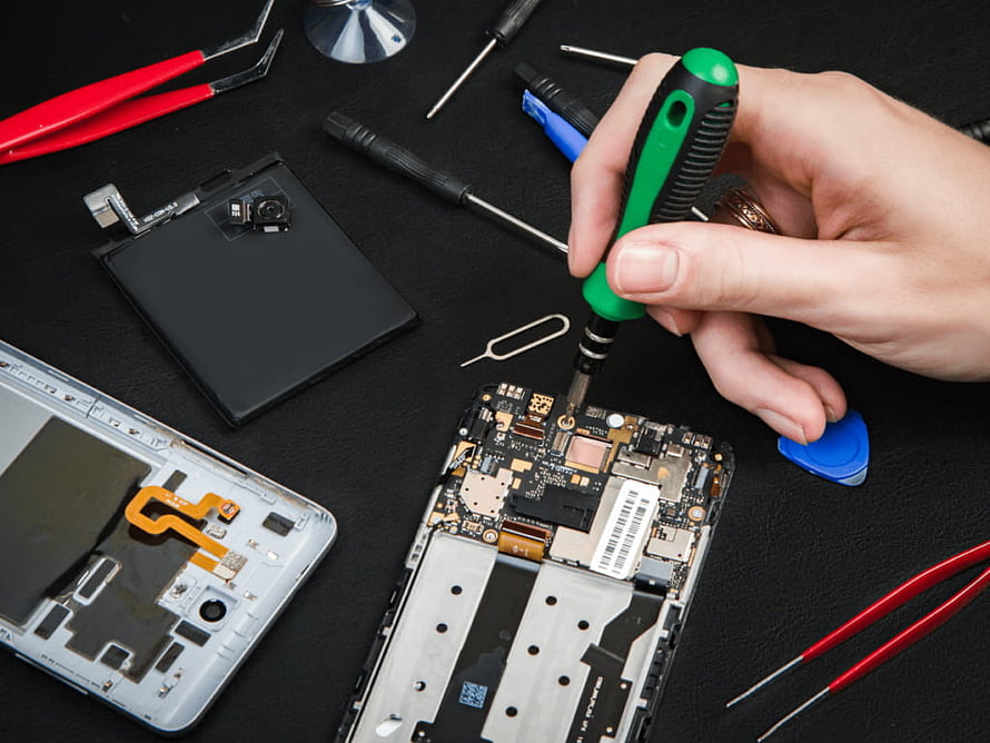 Mobile Phone Repair Technician Using Screwdriver on Circuit Board HD wallpaper