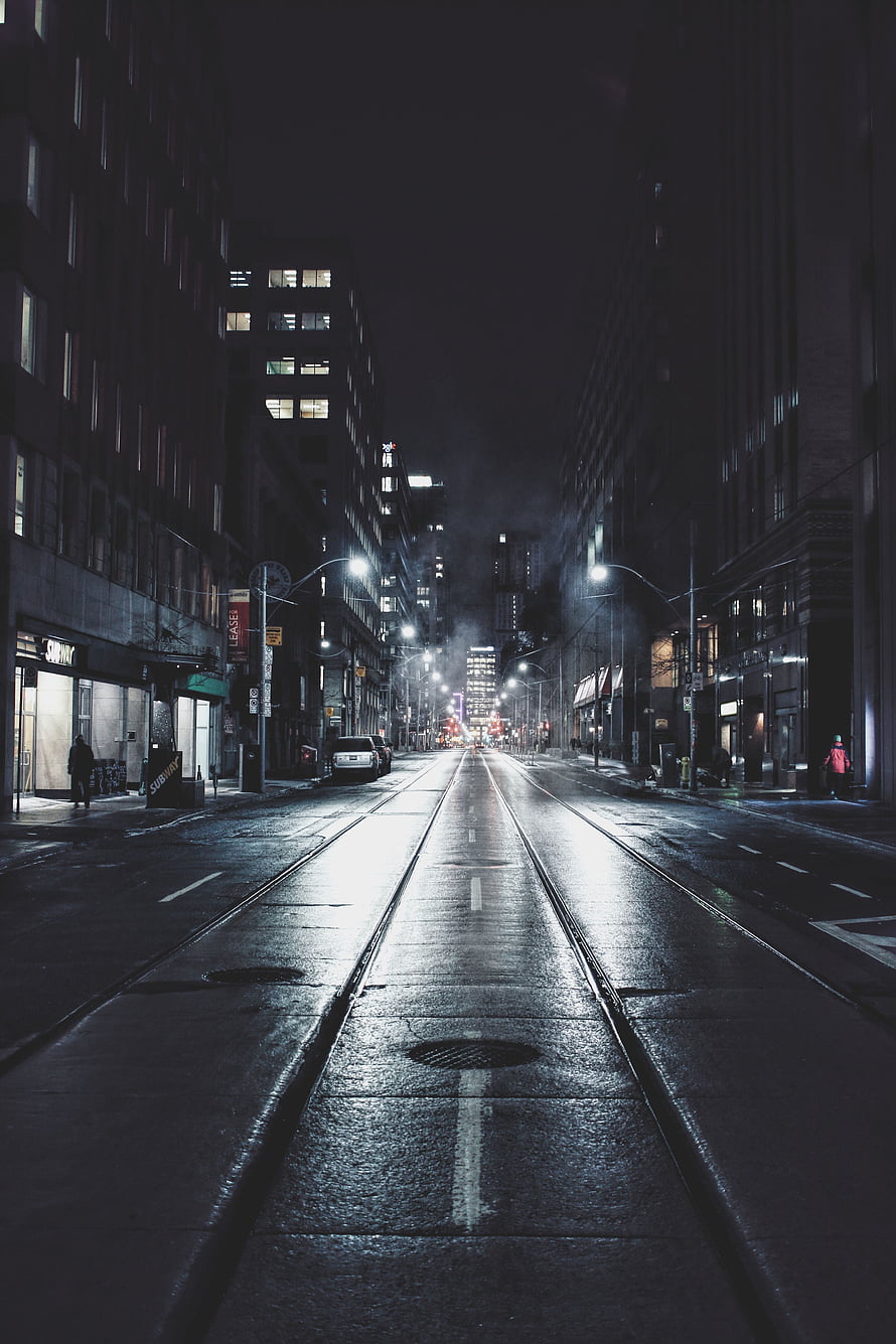 Moody Nighttime City Street with Wet Pavement and Tram Tracks HD phone wallpaper