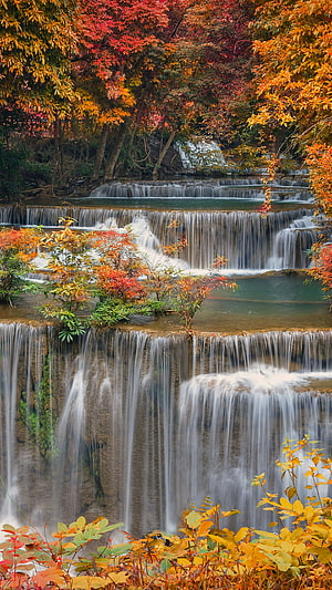 Tiered Waterfall Cascading Through Vibrant Autumn Forest Foliage HD phone wallpaper