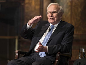 Warren Buffett Gesturing During a Formal Interview in a Dark Suit HD wallpaper