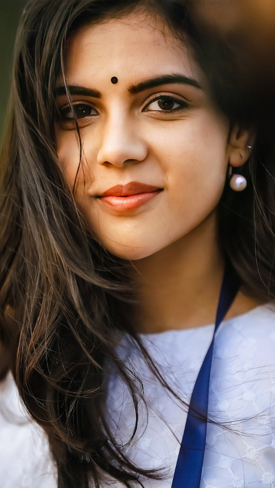 Portrait of a smiling young woman with a bindi and pearl earrings, Kalyani Priyadarshini, malayalam actress HD phone wallpaper