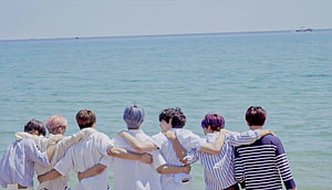 NCT Dream members standing together with arms around each other facing the ocean HD wallpaper