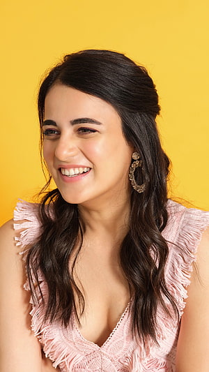 Radhika Madan smiling portrait in pink fringed top against yellow background HD phone wallpaper
