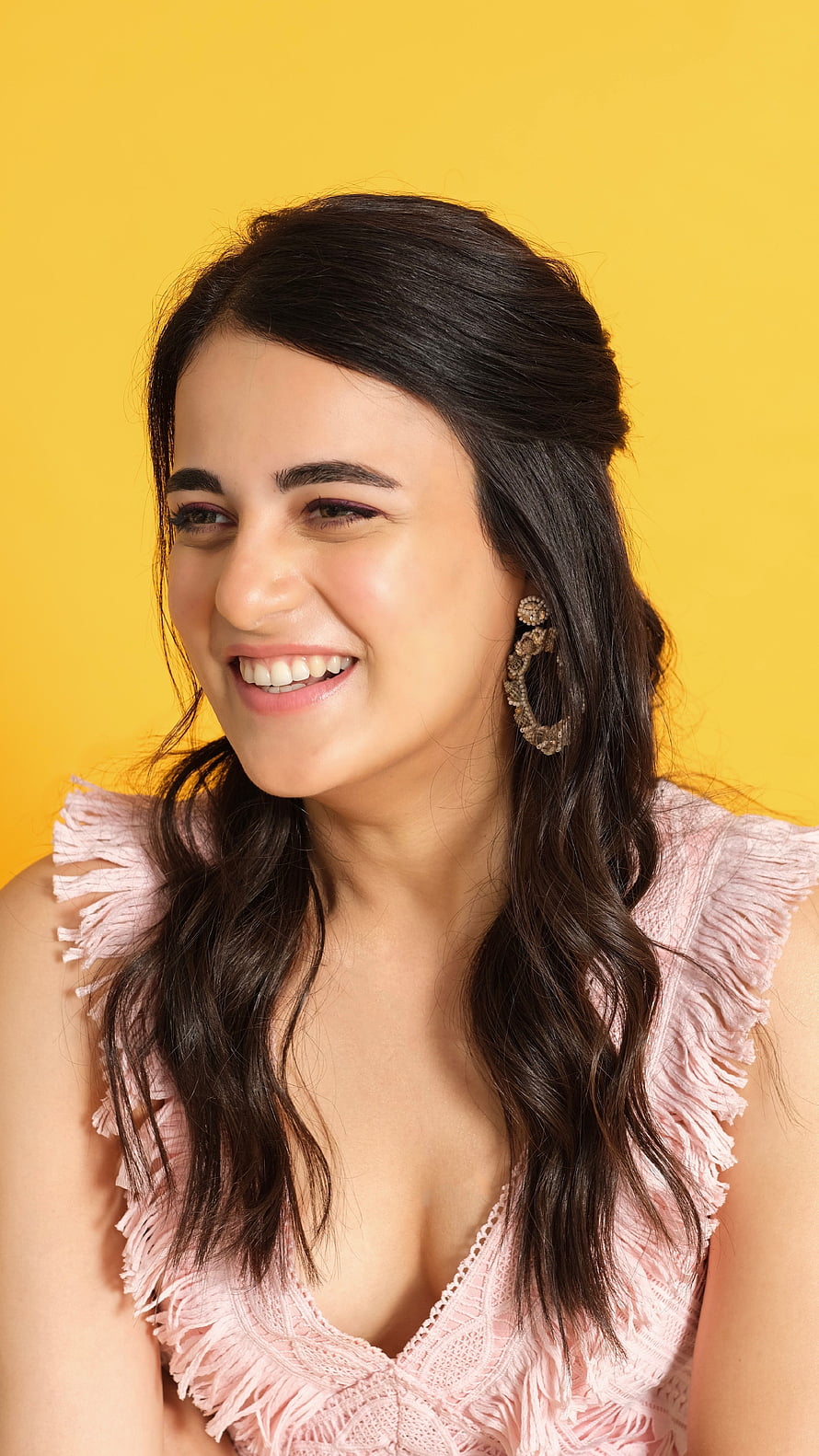 Radhika Madan smiling portrait in pink fringed top against yellow background HD phone wallpaper