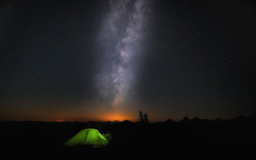 Glowing Green Tent Under the Milky Way Galaxy in a Mountainous Night Landscape HD wallpaper