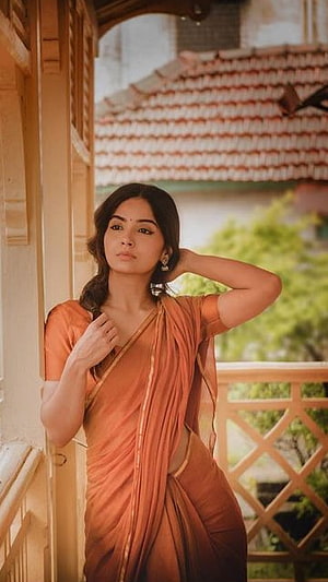 Kashmira Pardeshi in an elegant orange saree posing on a traditional balcony HD phone wallpaper