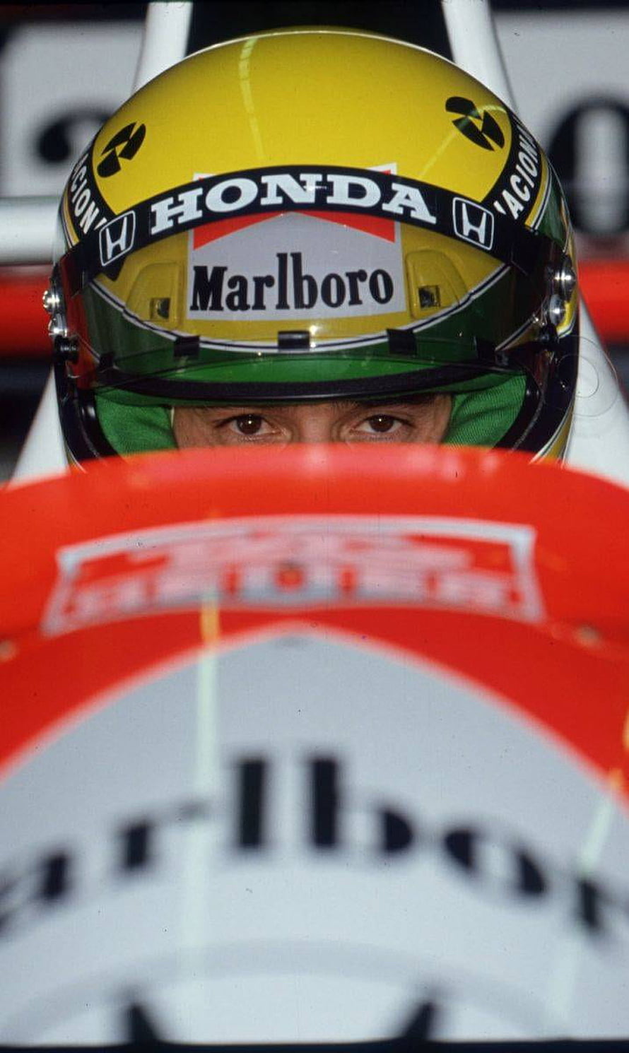 Ayrton Senna in a yellow Honda Marlboro racing helmet inside a Formula 1 cockpit HD phone wallpaper