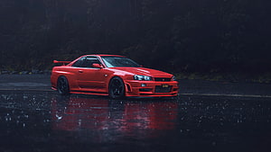 Red Nissan Skyline GT-R R34 parked on wet asphalt in the rain HD wallpaper