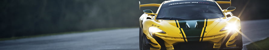 Yellow McLaren 720S GT3 race car with black racing stripes on a track HD wallpaper