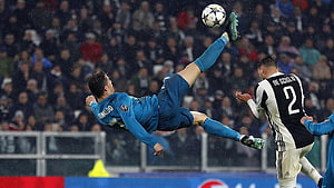 Cristiano Ronaldo performing a bicycle kick in a blue Juventus kit during a Champions League match HD wallpaper