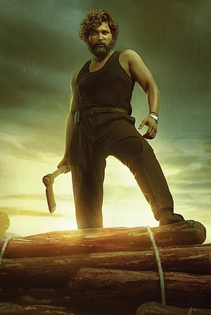 Pushpa Raj character poster with axe on stacked logs in dramatic golden light HD phone wallpaper