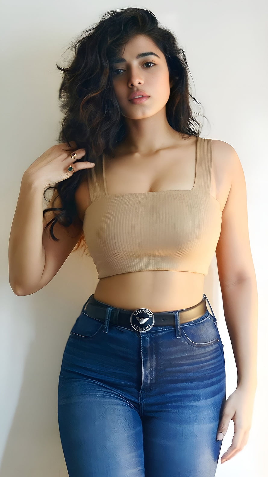 Woman in beige ribbed crop top and blue jeans posing against white wall, Kethika sharma, telugu actress HD phone wallpaper