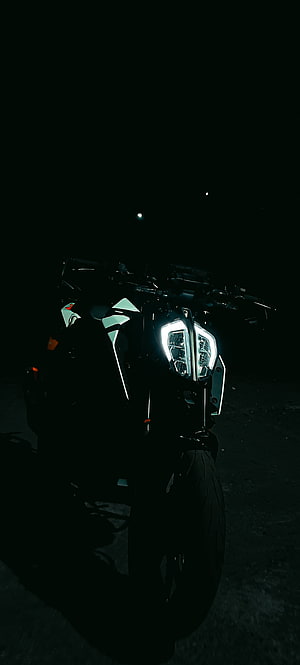 Dramatic Night Shot of a Motorcycle with Glowing LED Headlights in Darkness HD phone wallpaper
