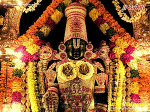 Lord Venkateswara adorned in gold jewelry and vibrant flower garlands at Tirumala temple HD wallpaper