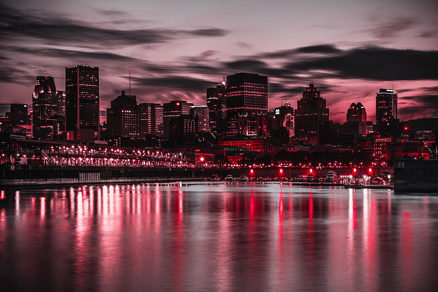 Vibrant Red and Pink City Skyline at Dusk with Water Reflections HD wallpaper