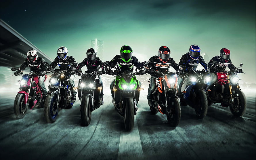 Seven Riders on Sport Motorcycles with Bright Headlights on a City Road at Night HD wallpaper